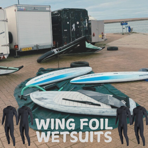 Wing foil boards and wetsuits on a seaside dock, ideal gear for wing foiling watersports.